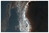 Rocce sedimentarie di colore chiaro esposte in una scarpata nella regione di Syrtis Major