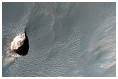 Небольшой кратер, содержащий светло-окращенный материал, внутри кратера Поллака