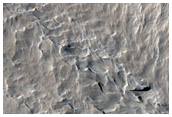 Pitted and Layered Materials in Olympus Mons Aureole
