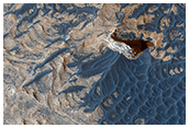 Materiale scuro a strati e ondulazioni in Melas Chasma