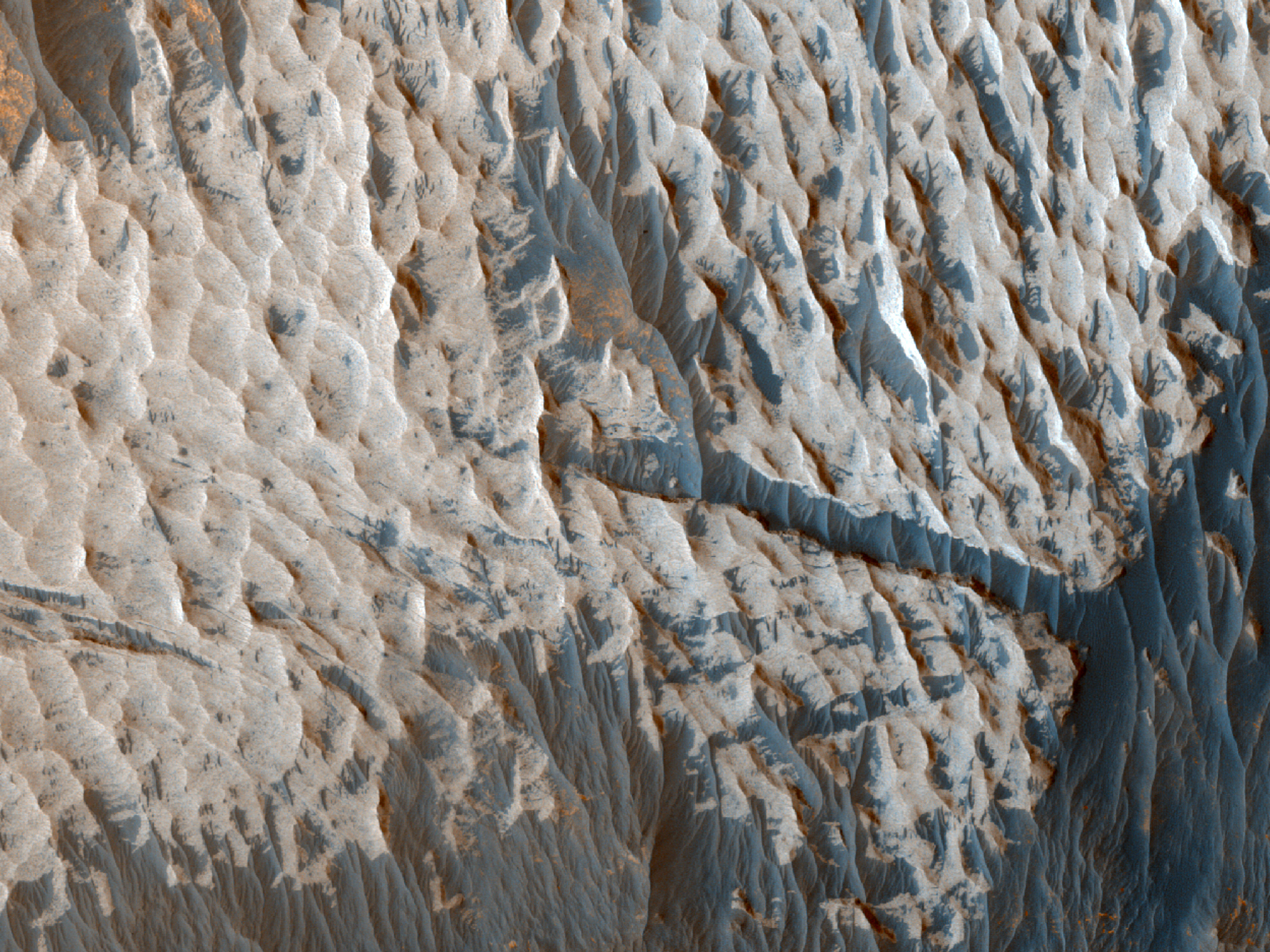 Afloraments rocosos de tonalitat clara a la paret sud-oest de Ophir Chasma