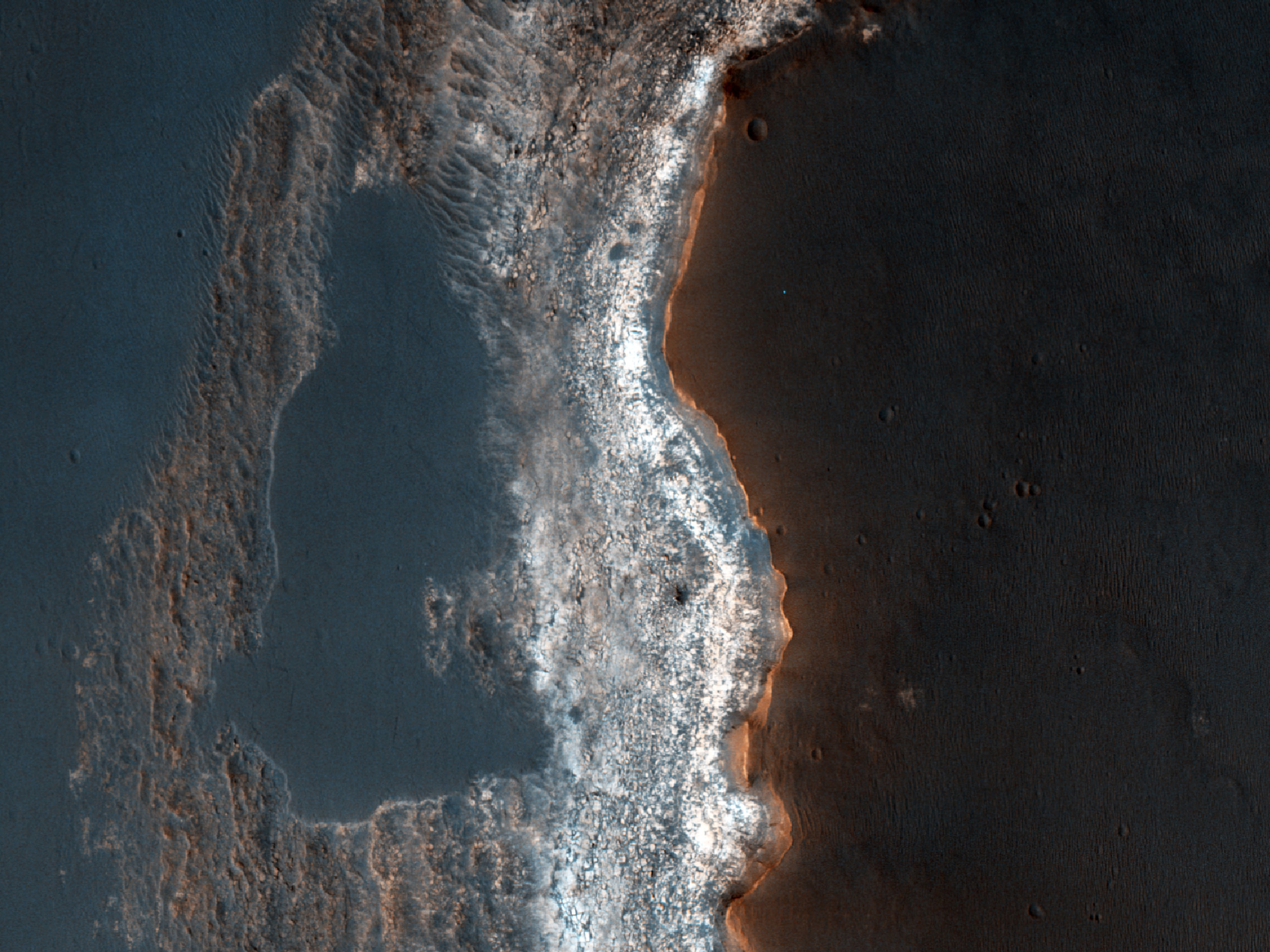 Rochas sedimentares expostas em um penhasco de cor clara na região de Syrtis Major