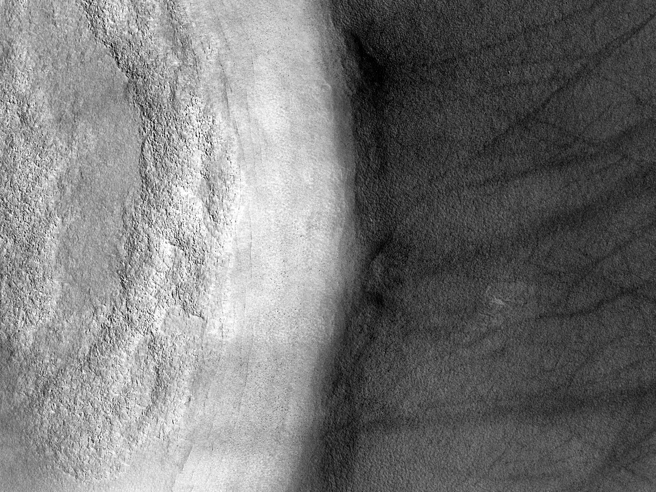 Estrias escuras na lateral de uma cratera de impacto nas plancies ao norte