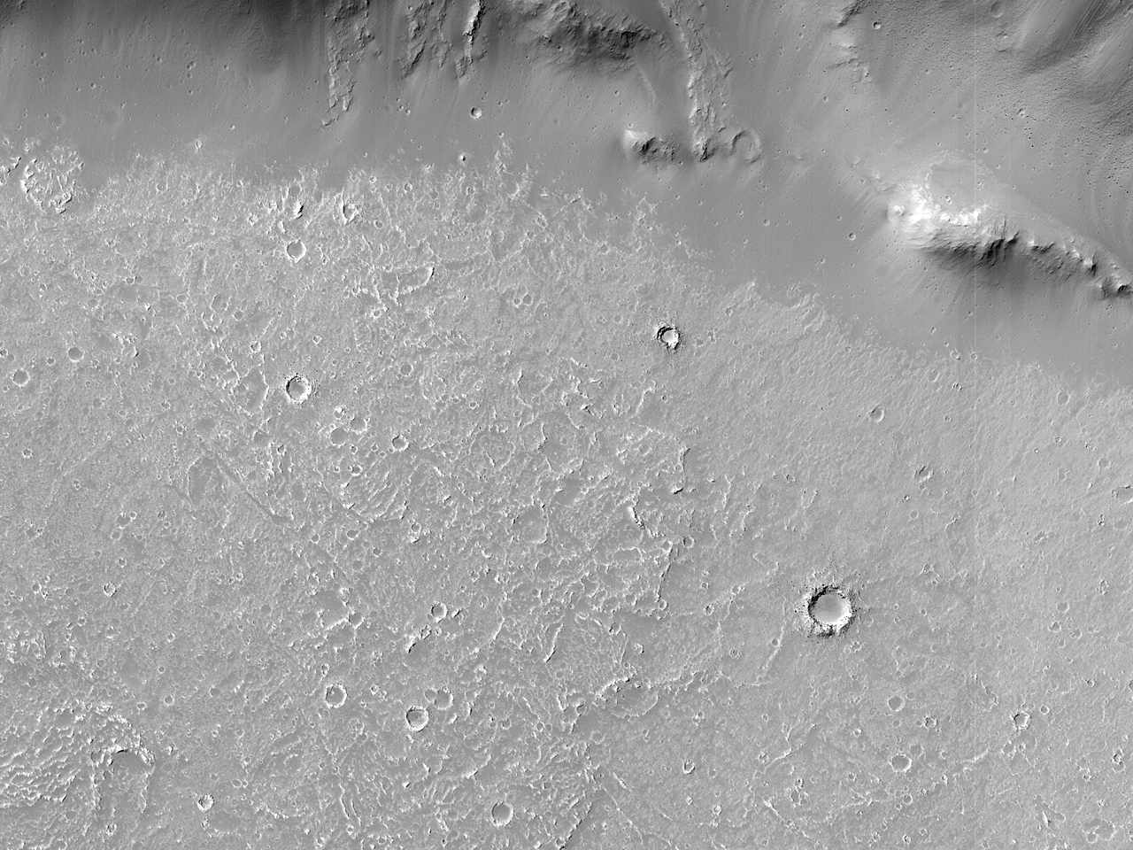 Krátersáncon és -falon átvágódó csatornából kiinduló folyásnyom a Daedalia Planumon