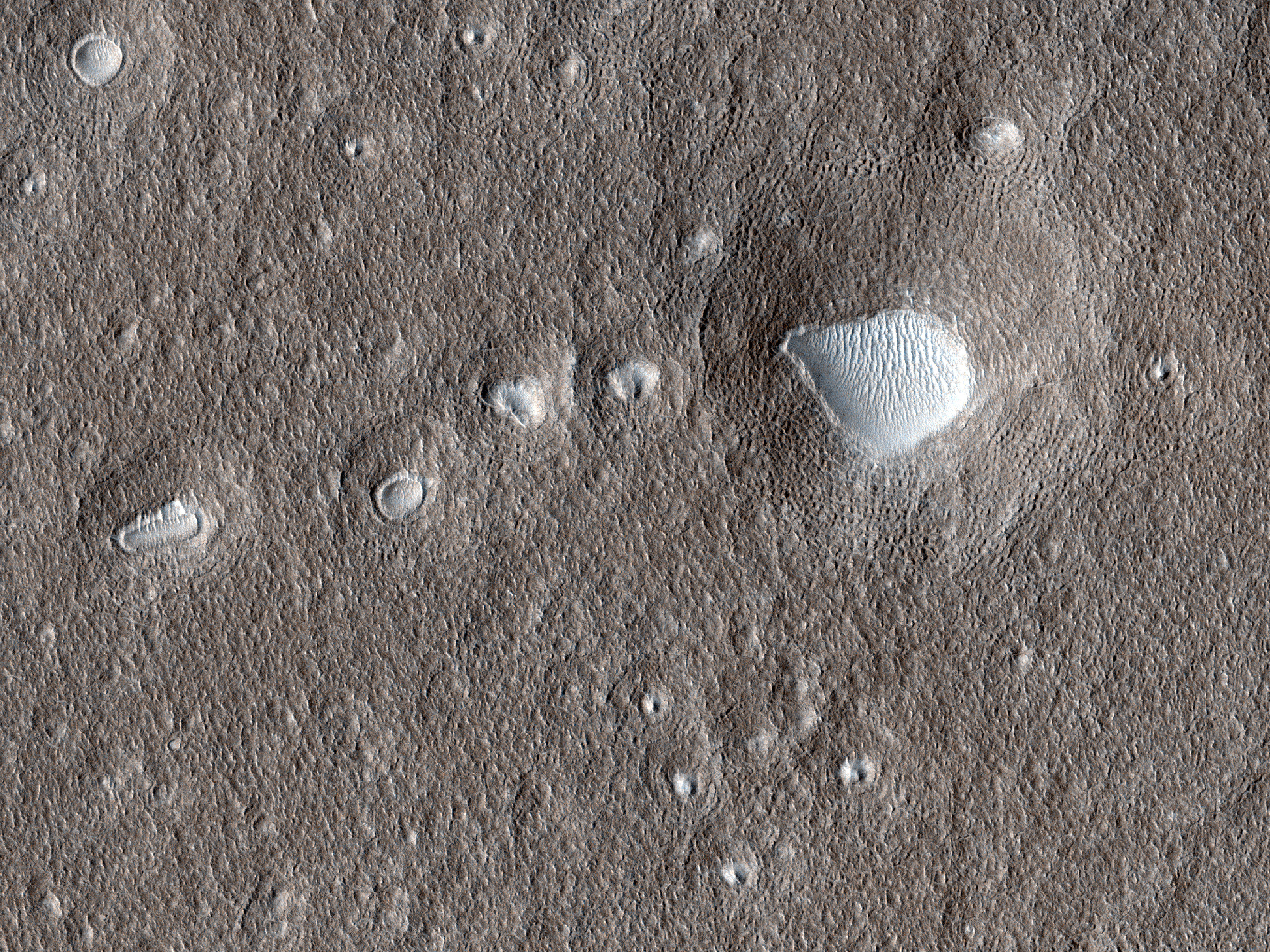 Crateras expandidas e pequenos montes nas planícies do norte