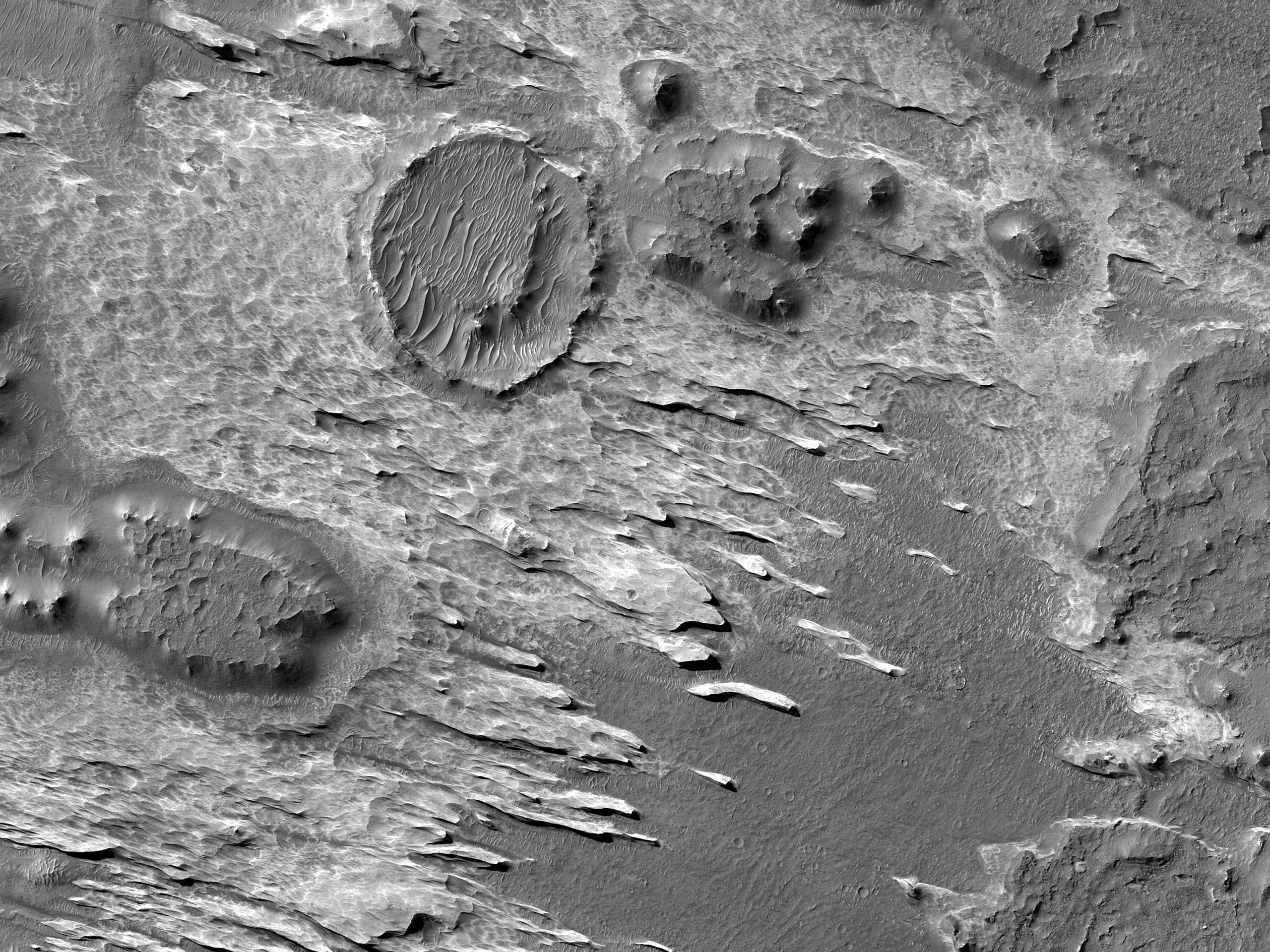 Кругла формація та невеликі пагорби на дні каньйону Melas Chasma