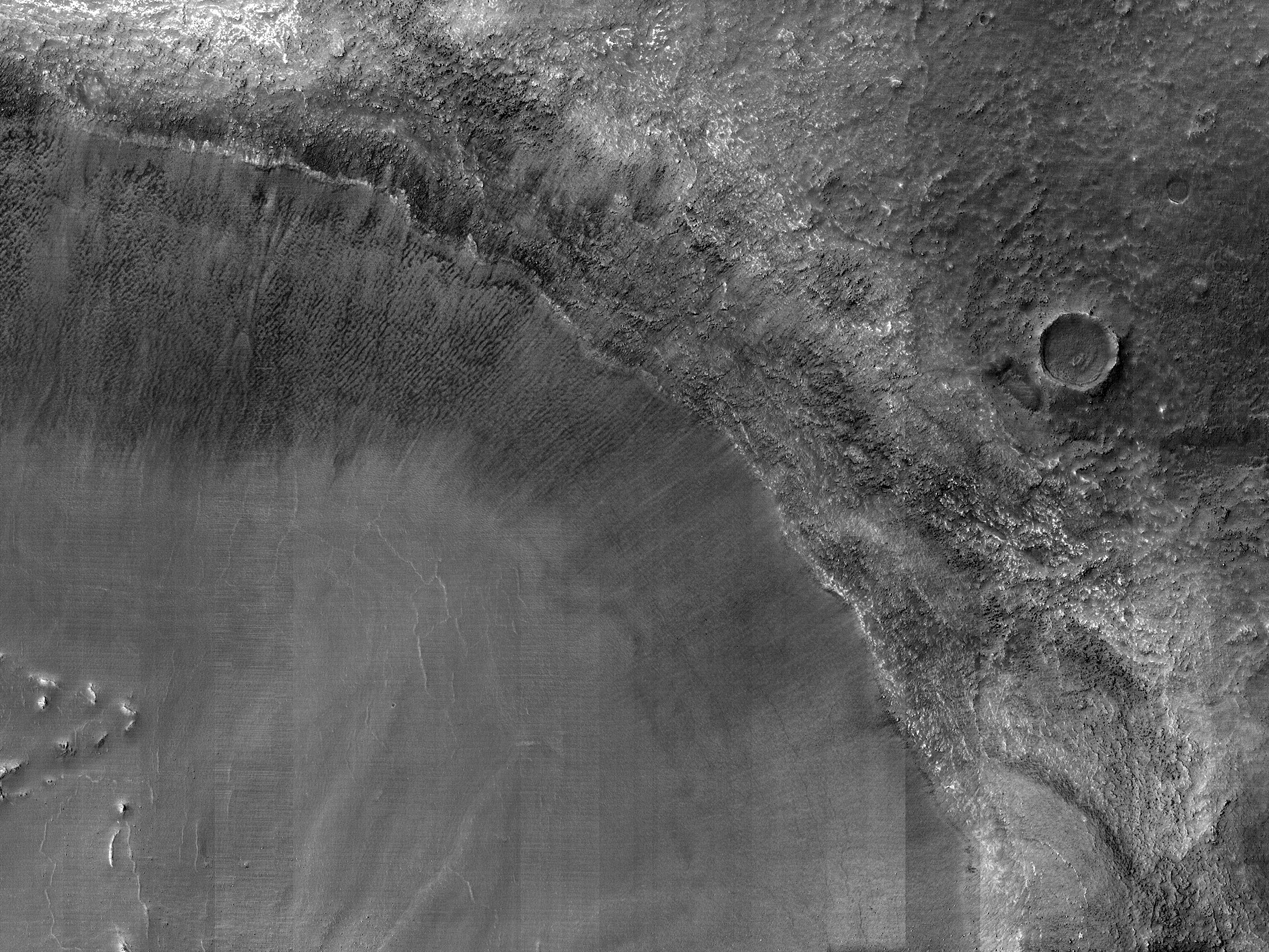 Barrancos en un pequeño cráter en Aonia Terra