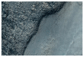 Ancient Valley Network Adjacent to Low-Albedo Outcrops