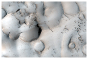 Cones and Pitted Material Inside An Embayed Crater in the Tartarus Montes