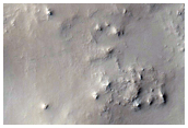 Dark Slope Feature Beneath Dark Lineation in Crater near Cusus Valles