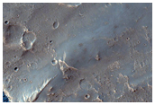 Ejecta Cut by Erosion in Sfax Crater along Edge of Ganges Chasma