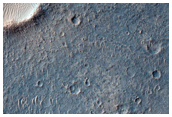 Crater with Radial Ridges Surrounded by Flow Feature