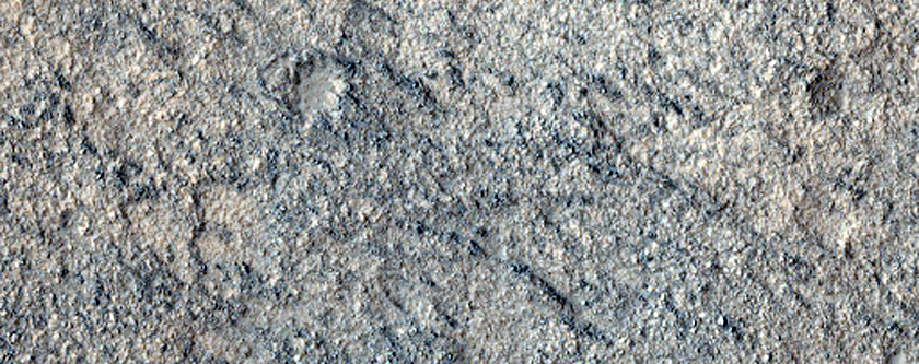 Sziklás lerakódás egy termális jelzésekkel borított kráter aljzatán