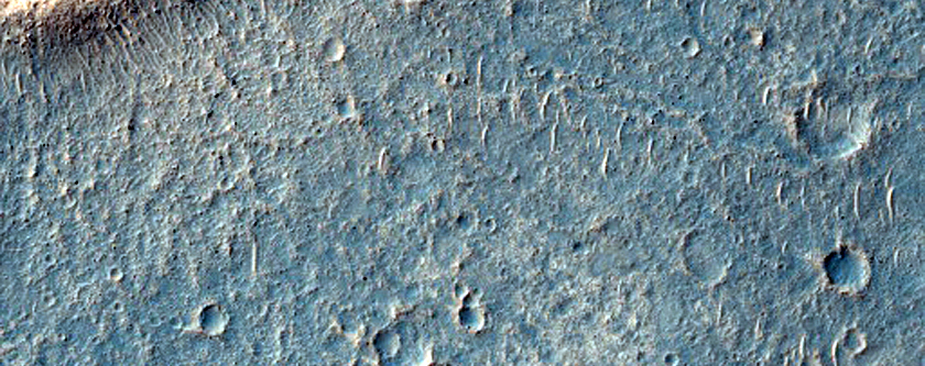 Crater with Radial Ridges Surrounded by Flow Feature