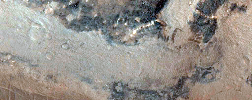 Mantle Material and Adjacent Low Albedo Surfaces