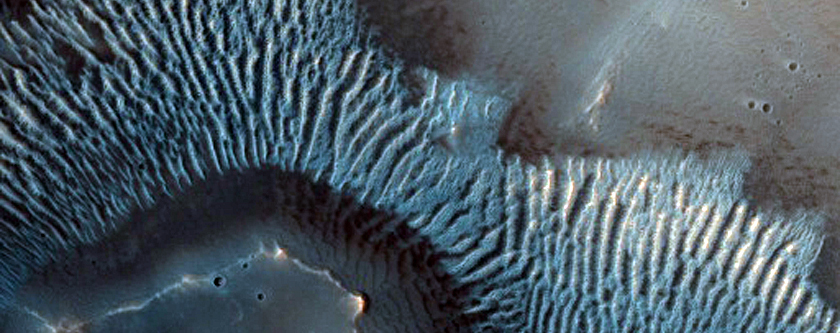 Crater with Pitted Materials and Possible Central Peak Bedrock Exposures