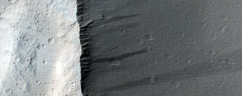 Pitted and Layered Materials in Olympus Mons Aureole