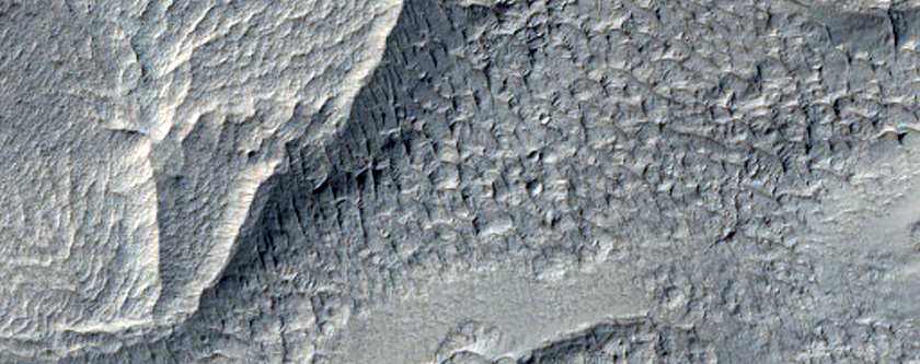 Flow-Like Features Possibly From Layered Ejecta of a Nearby Crater