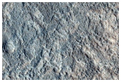 Dark Material on Promontories and Inliers of Crater Wall