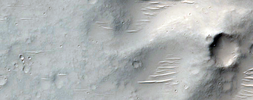Pitted Materials on Floor of 90-Kilometer Diameter Crater
