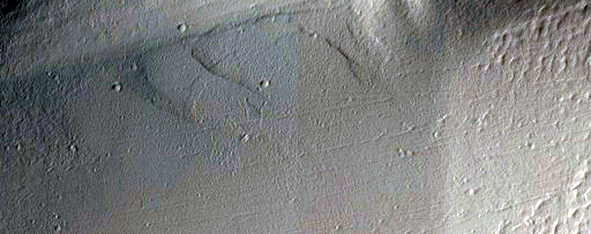 Ulysses Patera Stratigraphy Exposed in an Impact Crater Wall
