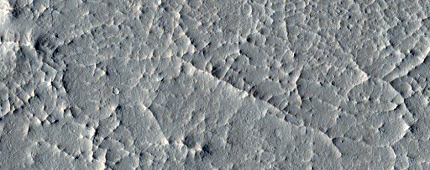 Layered Material and Sinuous Ridge Terminating at Semi-Elliptical Feature
