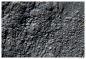 Fresh Crater in Hellas Basin with Striated Interior Fill and Pillow Ejecta