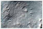 Small Fresh Impact Crater on Ejecta of Crater within Dejnev Crater