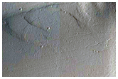 Ulysses Patera Stratigraphy Exposed in an Impact Crater Wall
