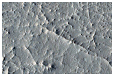 Layered Material and Sinuous Ridge Terminating at Semi-Elliptical Feature
