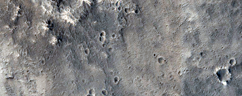 Layers on Wall of a Crater Interrupting a Channel