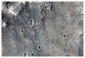 Layers on Wall of a Crater Interrupting a Channel