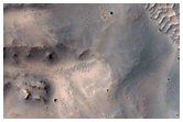Crater with Exposed Layered Walls Superposed on Ejecta of Larger Crater