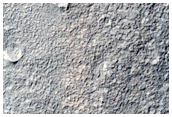 Layered Deposit in Small Crater and Wrinkle Ridge Near Reull Vallis