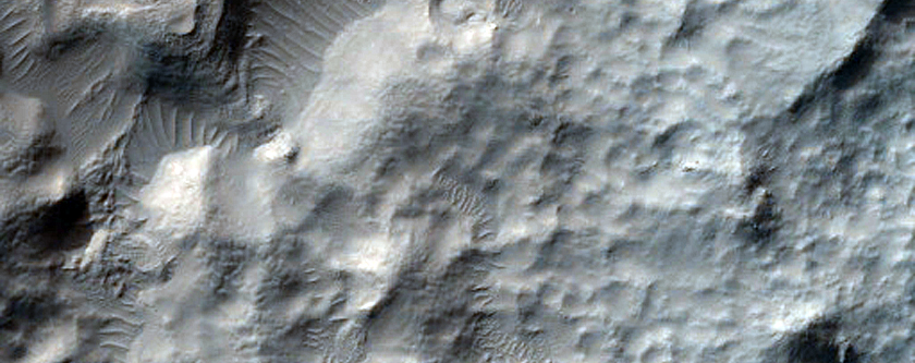 Crater-Related Pitted Materials in 8-Kilometer Diameter Hellas Region Crater