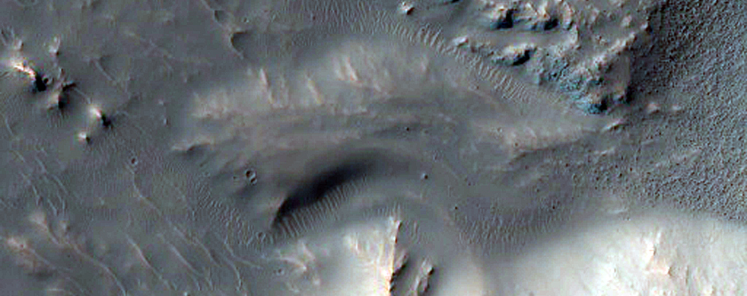 Djupa raviner i skugga i en krater