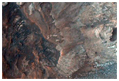 Crater with Light-Toned Wall Rock in Outflow Channel Floor