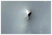 Crater Intersecting Degraded Impact Basin Rim