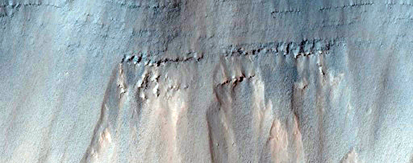 Stratified Material Beneath Crater on East Coprates Chasma Wall
