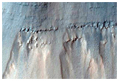 Stratified Material Beneath Crater on East Coprates Chasma Wall
