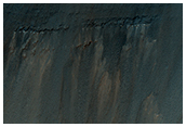 Stratified Material Beneath Crater on East Coprates Chasma Wall