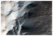 Exposed Bedrock Ridges with Flow Pitted Material in Hale Crater Ejecta
