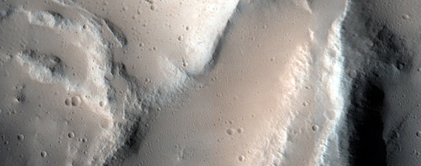Crater and Trough in Ceraunius Fossae
