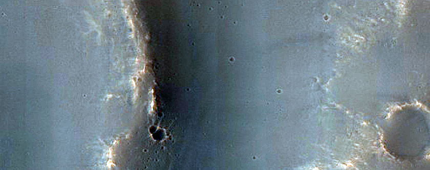 Crater in Bakhuysen Crater Ejecta with Possible Bedrock Exposures in Wall
