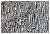 Mørke sedimenter og kurvede rygger i Medusae Fossae