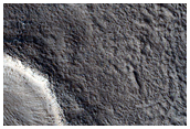 Crater with Preferential Ejecta Distribution on Possible Glacial Unit
