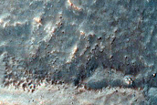 Barrancos en un pequeño cráter en Aonia Terra
