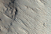 Crater with Channel Cutting Rim in Tartarus Colles