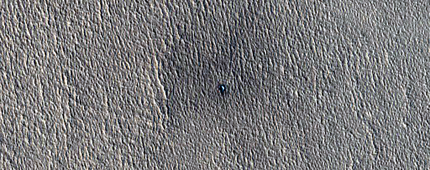 Monitoring an Ice-Exposing Crater West of Phlegra Montes