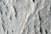 Sinuous Ridge Emergent From Beneath Crater Ejecta